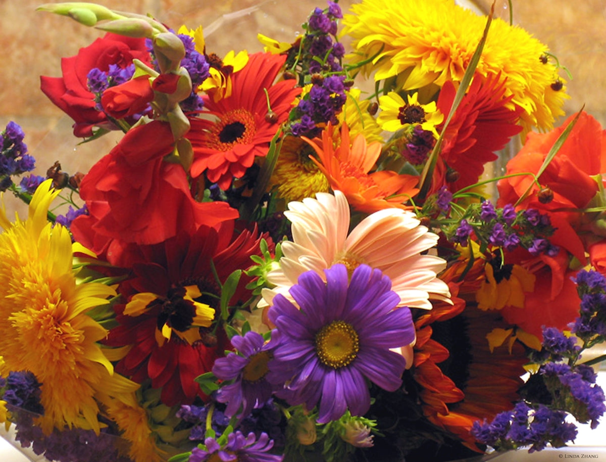 A vase filled with lots of colorful flowers