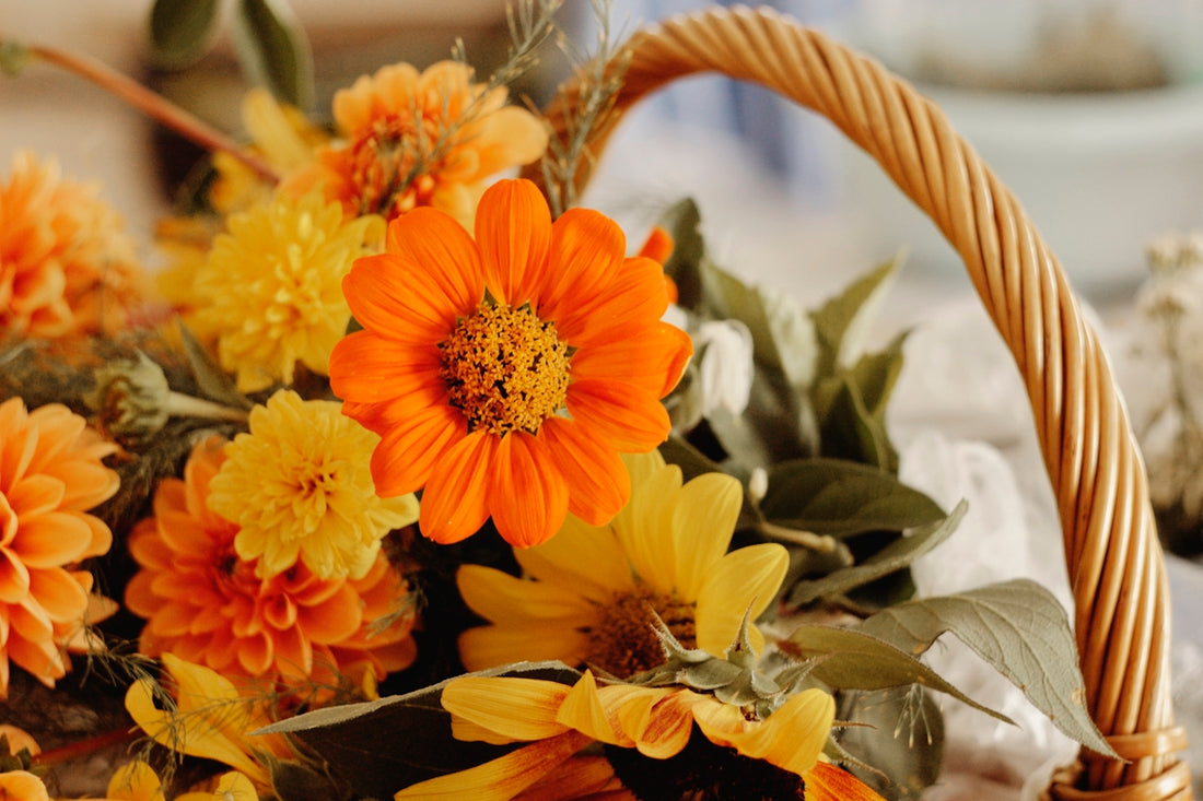 A basket filled with vibrant orange and yellow flowers.